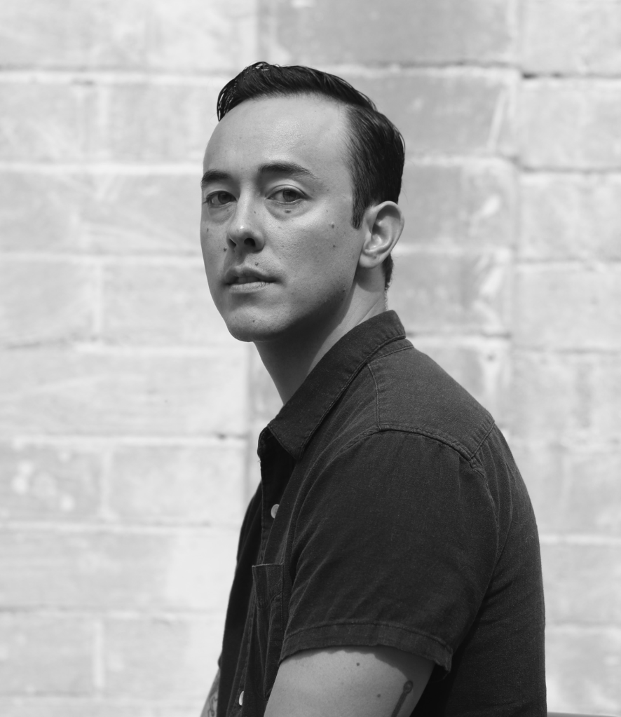 Author photo of Cameron Quan, a black and white image of the author standing in profile. Photo Credit: Zoe Lambert.